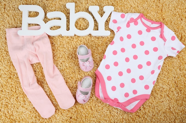 Clothes for baby girl on colorful background