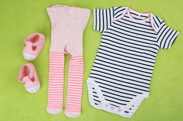 Clothes for baby girl on colorful background