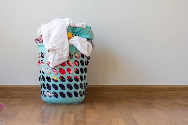 Photo clothes in basket on hardwood floor against wall