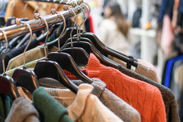 Clothes on coat hangers and shelves in a store