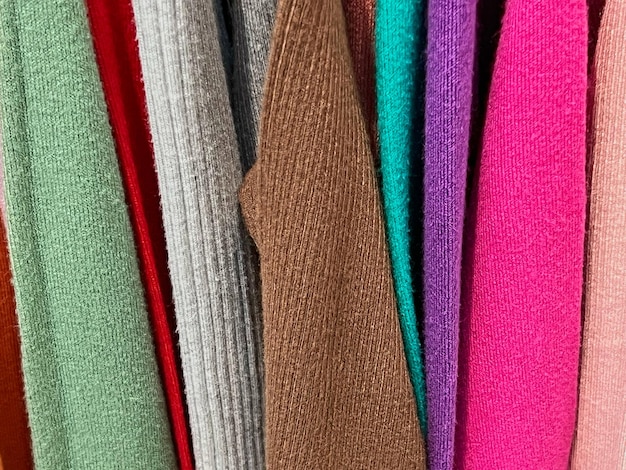 Clothes of different colors hanging on hanger closeup