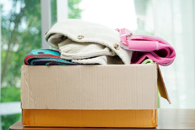 Clothes donations in cardboard box for volunteer