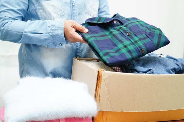 Clothes donations in cardboard box for volunteer