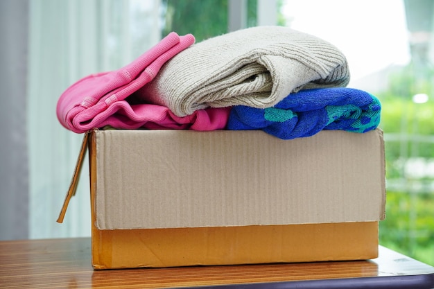 Photo clothes donations in cardboard box for volunteer