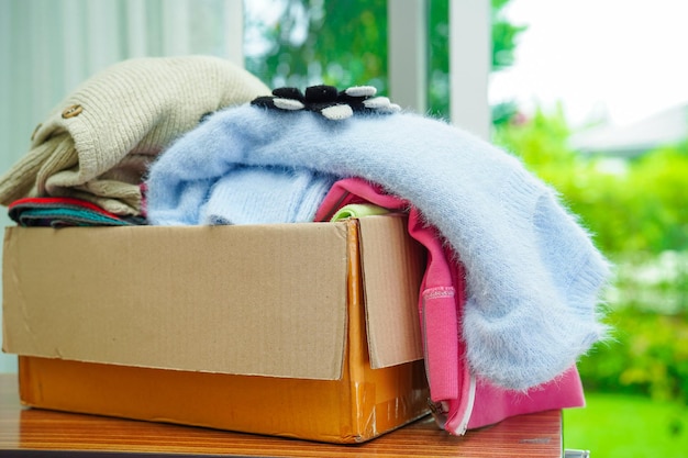 Photo clothes donations in cardboard box for volunteer