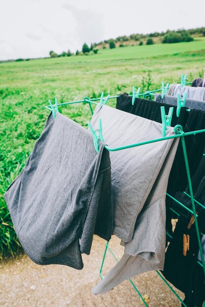 Clothes drying on clothesline on field against sky