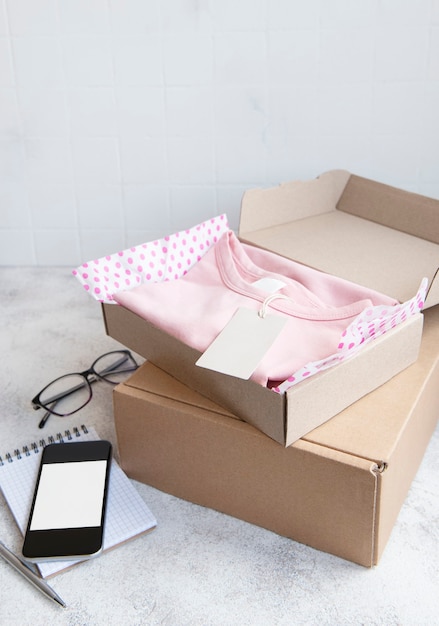 Фото Одежда для детей в открытой картонной коробке. концепция покупок в интернете. доставка одежды.
