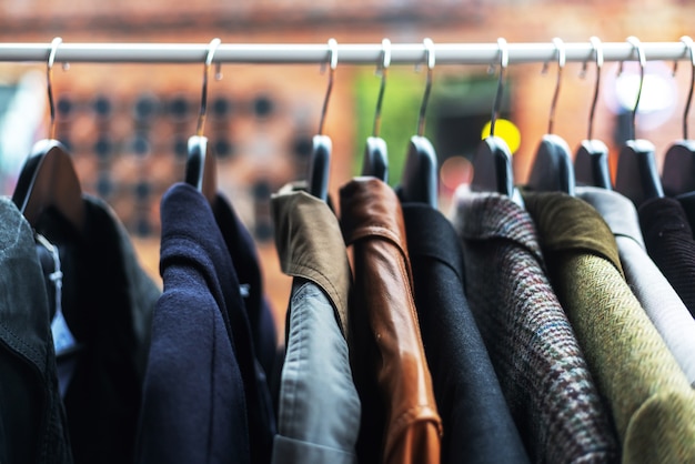 Clothes on the hangers at the flea market, low prices clothing
concept, image with soft focus