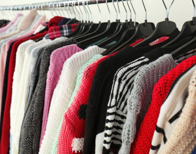 Clothes on hangers in modern shop, closeup