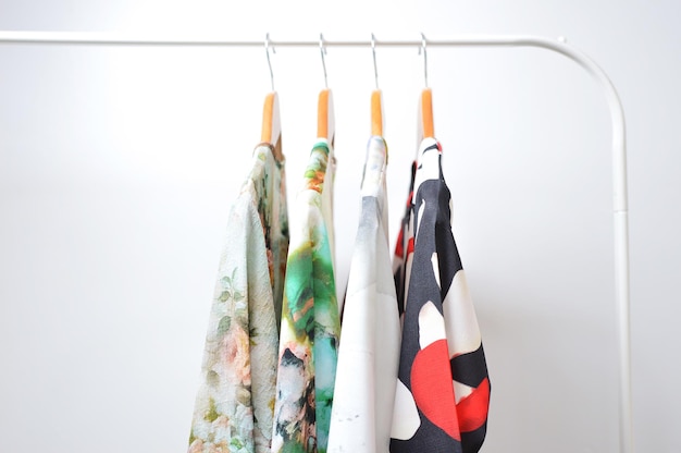 Clothes hanging on a rail in a white background.