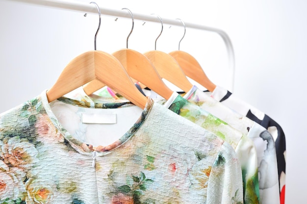 Clothes hanging on a rail in a white background.