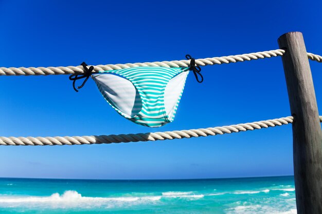 Clothes hanging on rope against blue sky