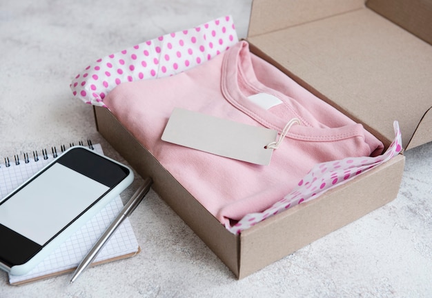 Clothes for kids in an open cardboard box. Online shopping concept