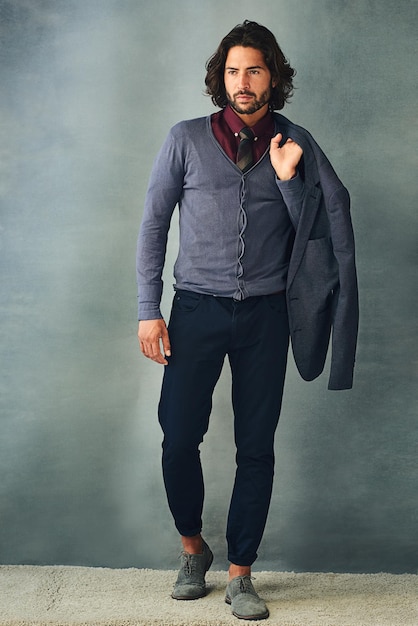 Clothes make the man Studio shot of a stylishly dressed handsome young man with his jacket over his shoulder