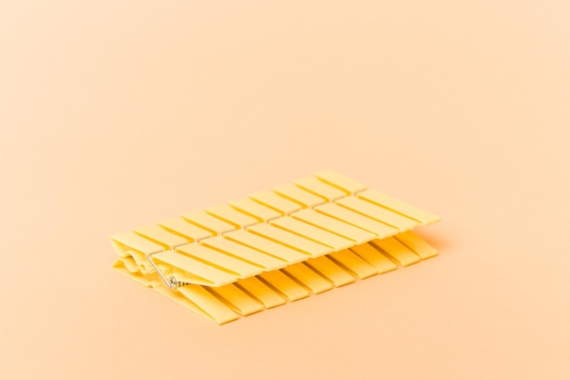 Clothes pin row isolated on beige background