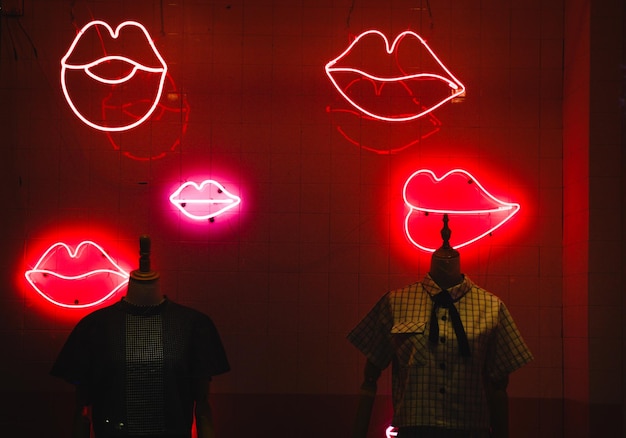 Clothes in retail display against illuminated red wall at store