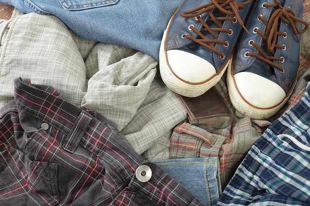 Clothes shoes and accessories Top view heap colorful jeans and gumshoes