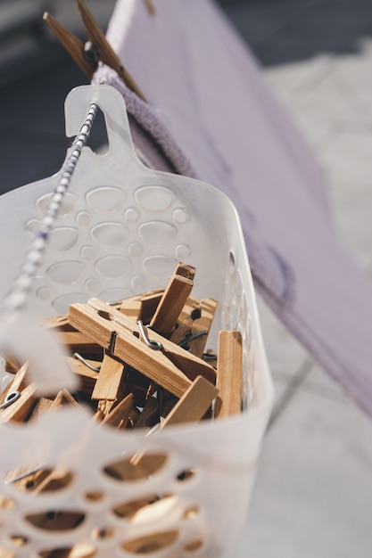 Clothespins hanging in a basket.