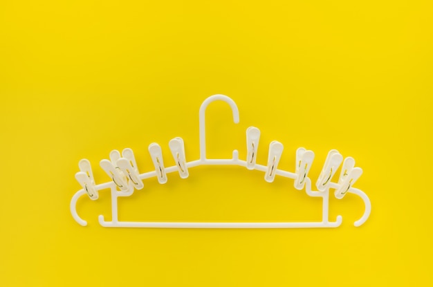 Clothespins with hangers on yellow background