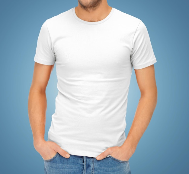 服のデザイン、広告、ファッション、人々 のコンセプト - 青い背景に空白の白い t シャツで ma のクローズ アップ