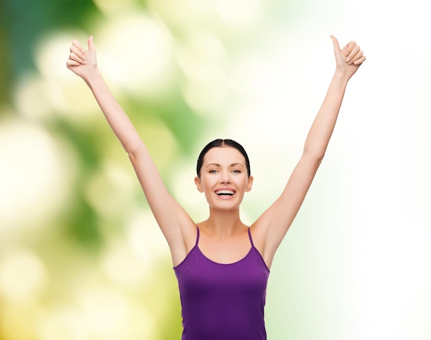 clothing design and happy people concept - smiling girl in blank purple tank top showing thumbs up