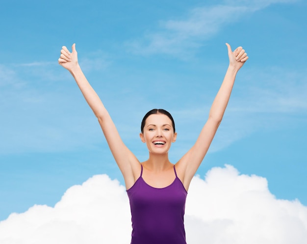 clothing design and happy people concept - smiling girl in blank purple tank top showing thumbs up