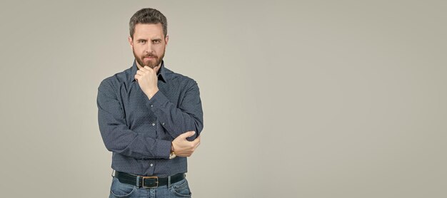 写真 深刻な男のための服 あごひげを生やした男は灰色の背景だと思います