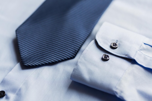 Clothing, formal wear, fashion and objects concept - close up of shirt and patterned tie