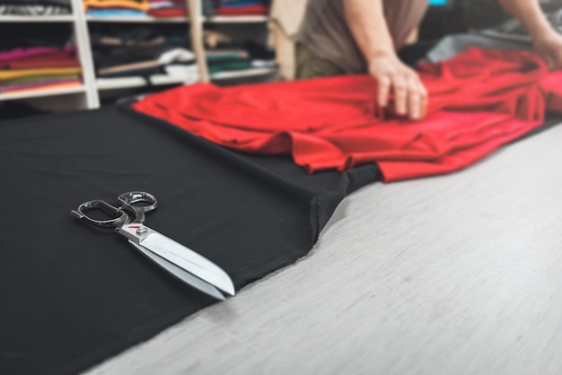 Clothing industry worker tailoring fabric on a table
