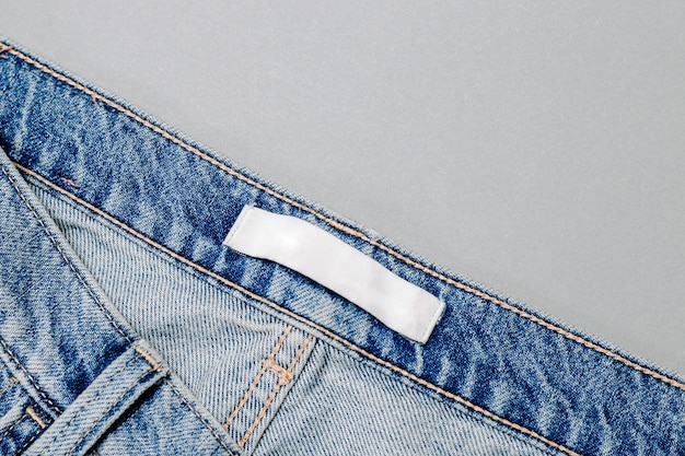 Clothing label inside jeans on grey background. mockup. close up