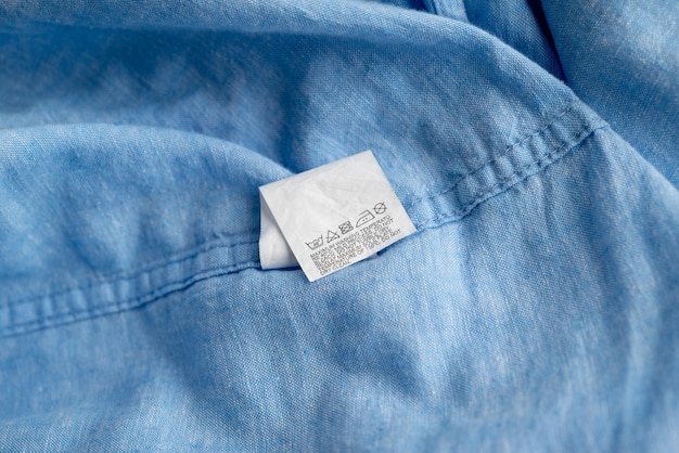 Photo clothing label on light blue garment top view