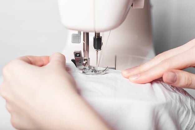 Одежда на швейной машине крупным планом, женские руки.