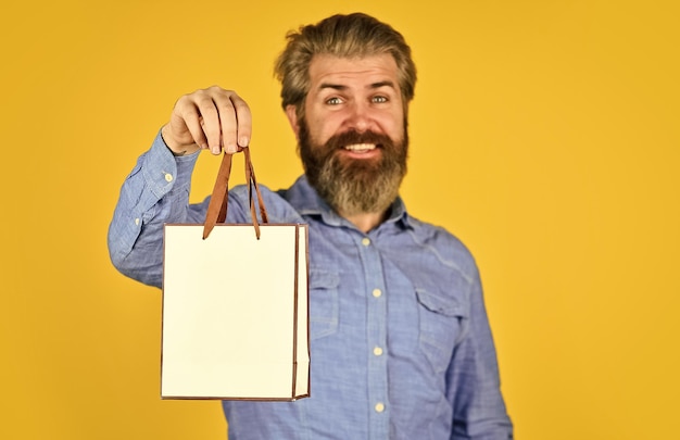 Clothing store cyber monday or black friday thanks for your purchase happy man with beard after shopping best sale and discount here gifts for holiday mature hipster carry shopping bag