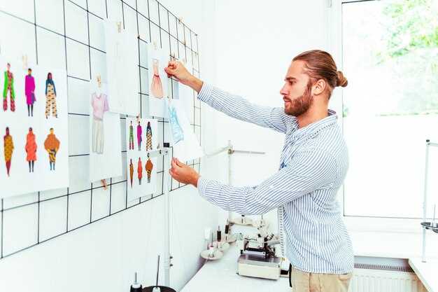 Clothing stylist creating a new design for a dress - Fashion designer working on a clothing brand in a textile factory