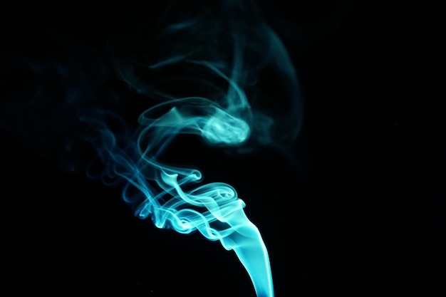 Cloud of abstract blue smoke in front of a black background