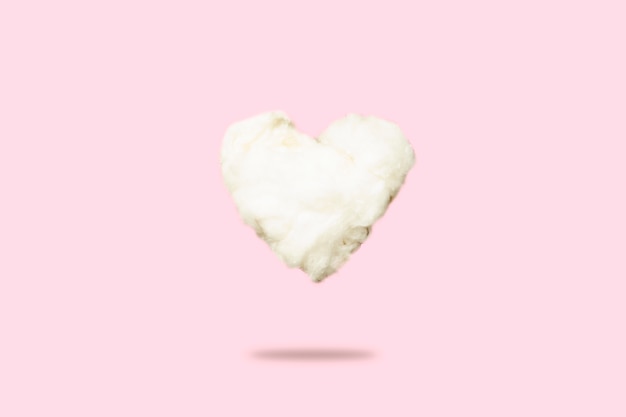 Cloud of cotton wool in the shape of a heart on a pink. Love Concept, Valentine's Day.