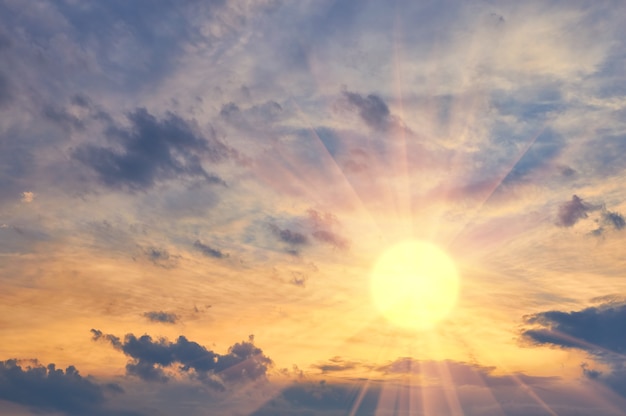 夕焼けの夕方の空と明るい太陽を光線で曇らせる | Premium写真