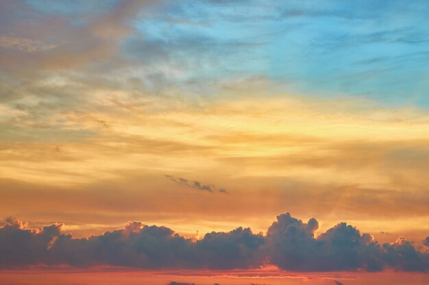 夕焼けの夕方の空を劇的な雲で曇らせる