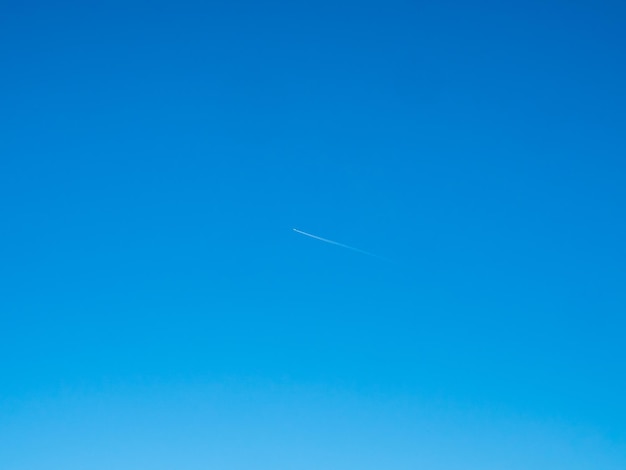青い空を背景に雲とジェット飛行機雲