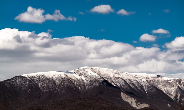 Cloud over snow capped mountain peaks