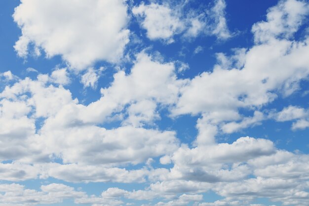 青い空の雲。青い空に白いふわふわの雲。背景の性質。青い空に浮かぶテクスチャ積雲。背景の概念。環境、雰囲気。碑文またはロゴの場所