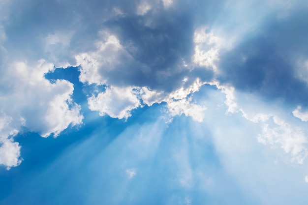 Clouds in blue sky with sun rays