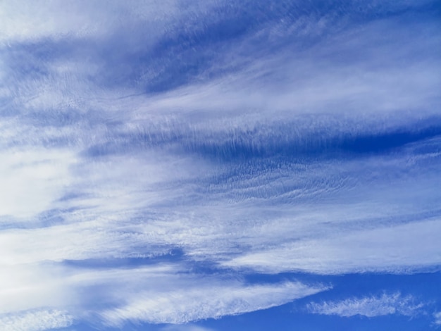 clouds illuminated by sunlight on a bright blue sky background