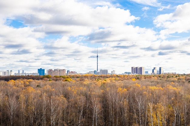 Clouds in sky over autumn park and city on horizon