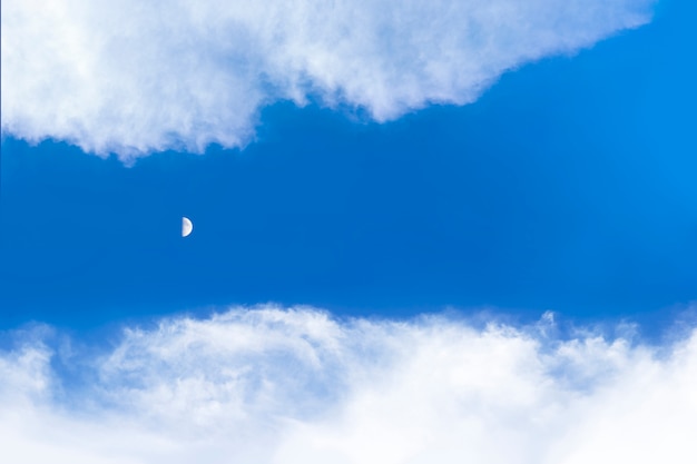 日中の雲空と月