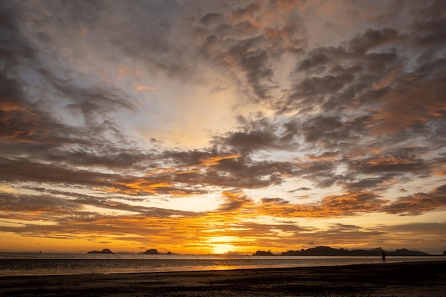 Nubi sul cielo riflesso del sole nell'acqua e sabbia sulla spiaggia