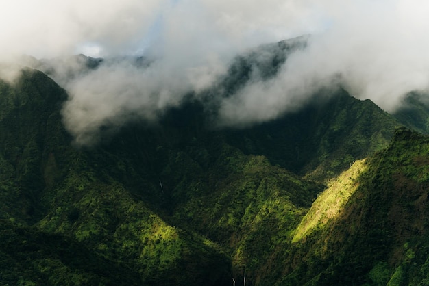 Clouds swirling around mountains of kauai as seen from helicopter