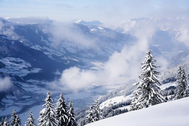 チロルのZillertalにあるZillertalArenaスキーリゾートの雲。冬のオーストリア、アルプスのマイヤーホーフェン。雪のアルプス山脈。下り坂の楽しみ。ツェルアムツィラーの青い空と白い斜面