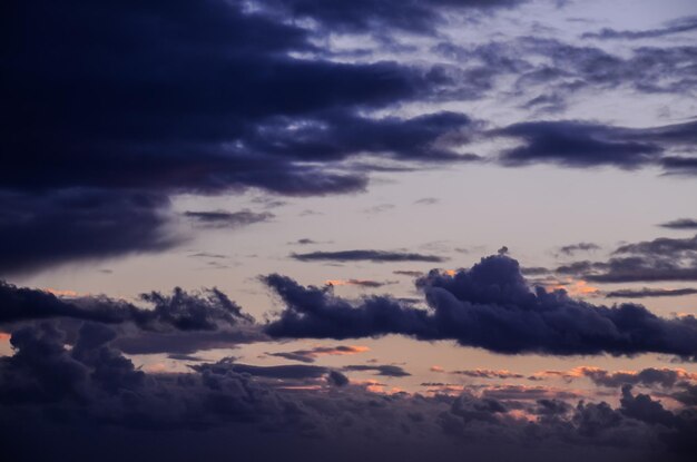 Photo cloudscape, colored clouds at sunset near the ocean