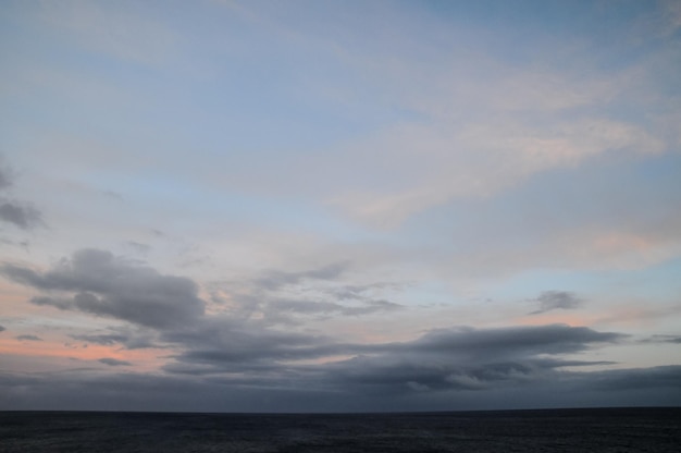 Cloudscape, gekleurde wolken bij zonsondergang in de buurt van de oceaan